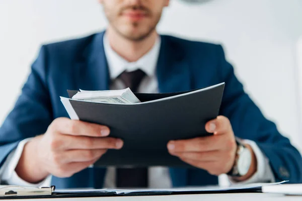 Foco seletivo do empresário segurando pasta com dinheiro — Fotografia de Stock