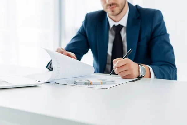 Cropped view of businessman holding document near bribe — Stock Photo