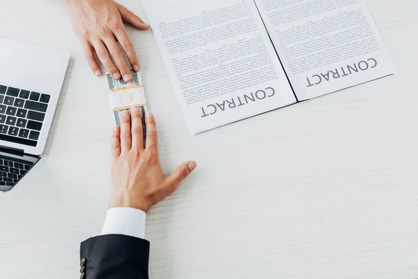 Top view of businessman giving bribe to man near contract on table — Stock Photo