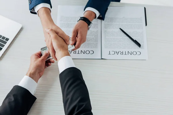 Top view of man giving money and shaking hands with business partner — Stock Photo