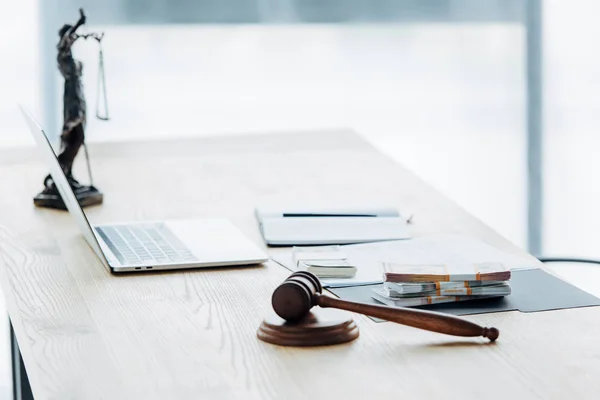 Selective focus of money on folder near statuette of justice — Stock Photo