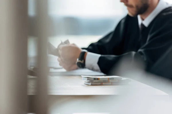 Selective focus of judge near dollar banknotes on table — Stock Photo