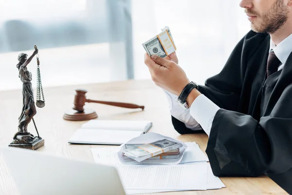 Cropped view of judge holding money near envelope and documents — Stock Photo