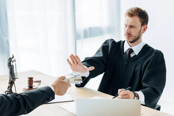 Abgeschnittene Ansicht eines Mannes, der unzufriedenen Richtern Geld in die Hand drückt und im Amt gestikuliert — Stockfoto