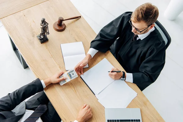 Top view of man giving cash to judge sitting in office — Stock Photo