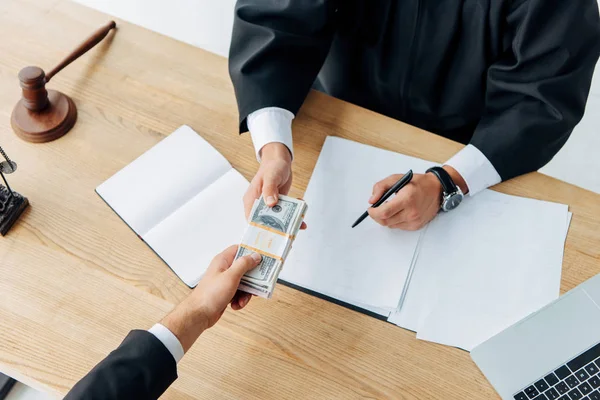 Top view of man giving bribe to judge holding pen in office — Stock Photo