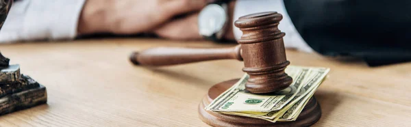 Panoramic shot of wooden gavel on dollar banknotes — Stock Photo