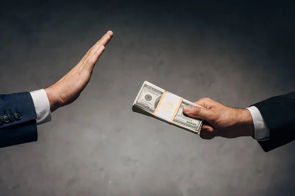 Cropped view man giving bribe to business partner gesturing on grey — Stock Photo
