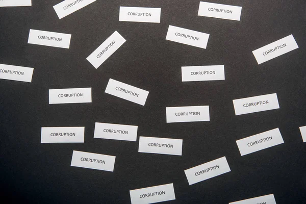 Top view of white papers with corruption letters on grey — Stock Photo