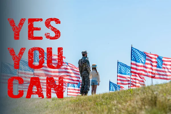 Hombre en uniforme militar de pie con hija cerca de banderas americanas con sí se puede ilustrar - foto de stock
