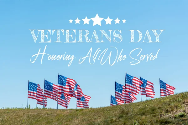 National american flags on green grass against blue sky with veterans day, honoring all who served illustration — Stock Photo