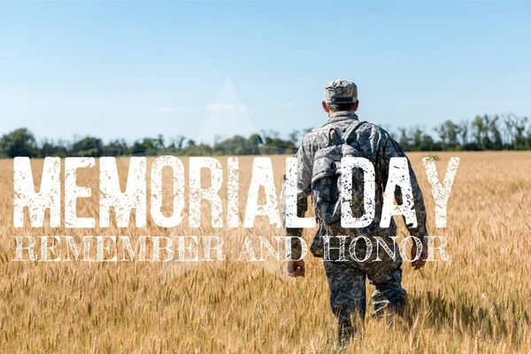 Солдат в военной форме с рюкзаком стоя в поле с золотой пшеницей с памятным днем, помните и честь иллюстрации — стоковое фото