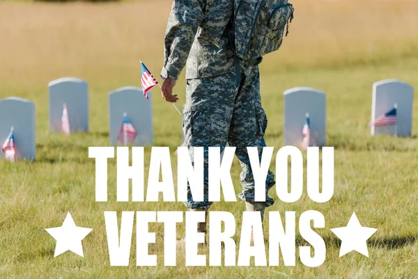 Ausgeschnittene Ansicht eines Militärmannes mit amerikanischer Flagge in der Nähe von Grabsteinen auf dem Friedhof mit Danksagung Veteranen Illustration — Stockfoto