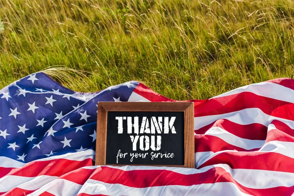 Kreidetafel mit Dankeschön für Ihre Service-Illustration auf amerikanischer Flagge mit Sternen und Streifen auf grünem Gras — Stockfoto