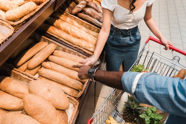 Blick über den Kopf eines Afroamerikaners, der mit dem Finger auf Brot im Supermarkt zeigt — Stockfoto