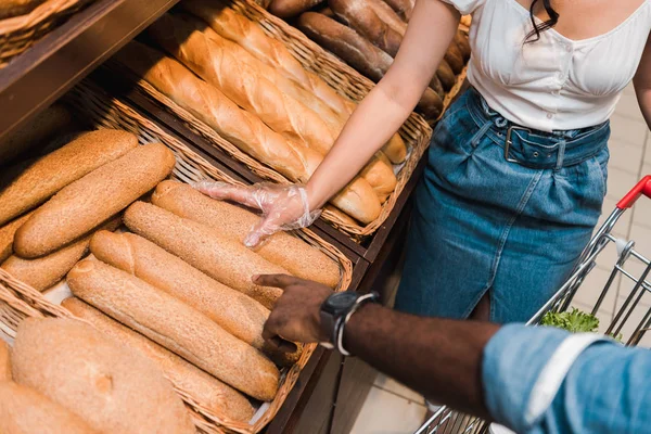 Visão cortada do homem americano africano apontando com o dedo para o pão no supermercado — Fotografia de Stock