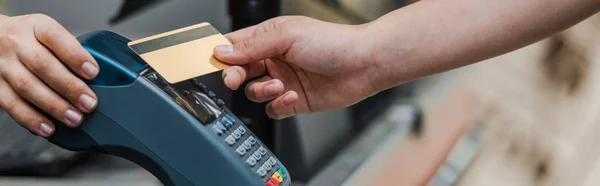 Tiro panorâmico do homem que paga pelo cartão de crédito perto do caixa no supermercado — Fotografia de Stock