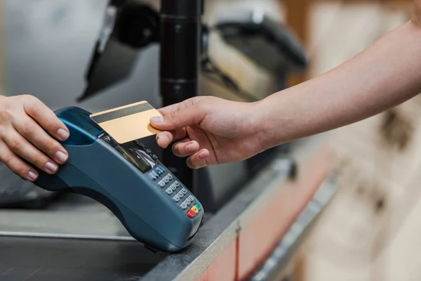 Cropped view of man paying by credit card near cashier in supermarket — Stock Photo