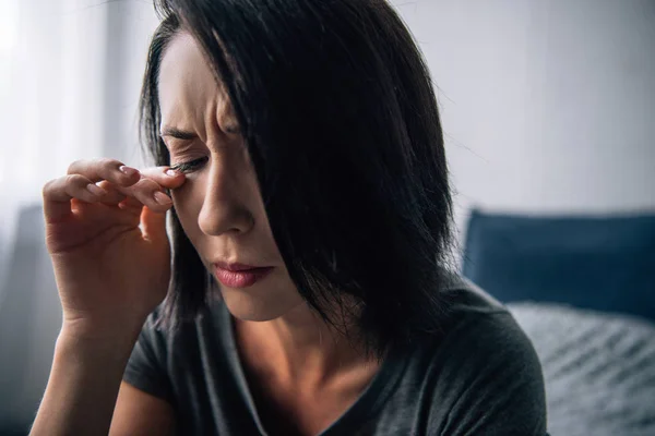 Schöne depressive Frau weint und wischt sich zu Hause Tränen — Stockfoto