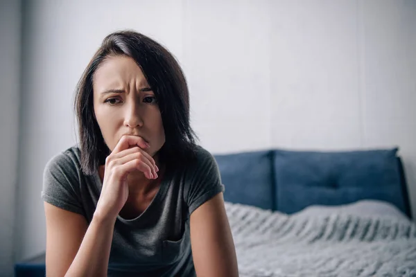 Beautiful depressed woman touching chin at home with copy space — Stock Photo