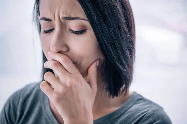 Bella donna triste che copre la bocca a casa — Foto stock