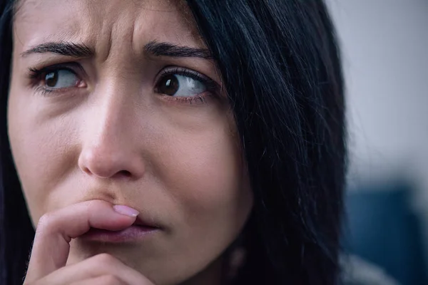 Beautiful upset woman covering mouth at home and looking away — Stock Photo