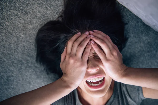 Depressive einsame brünette Frau bedeckt Gesicht mit Händen und weint zu Hause — Stockfoto