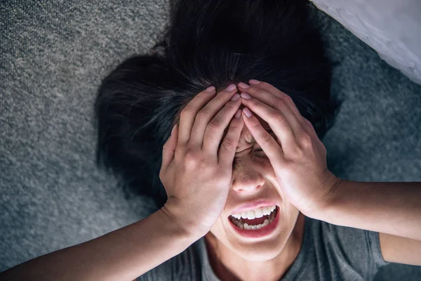 Depressed lonely brunette woman covering face with hands and crying at home — Stock Photo