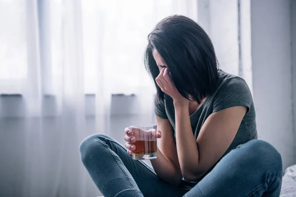 Donna depressa con bicchiere di whisky che piange a casa — Foto stock