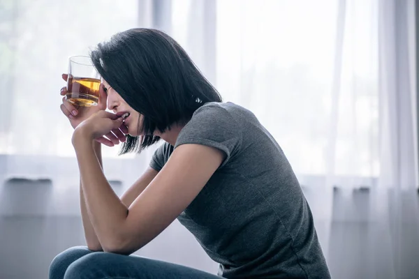 Einsame Frau zu Hause mit Whiskeyglas verärgert — Stockfoto