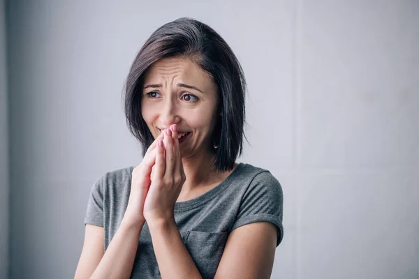 Triste morena mujer cubriendo la boca y llorando en casa - foto de stock