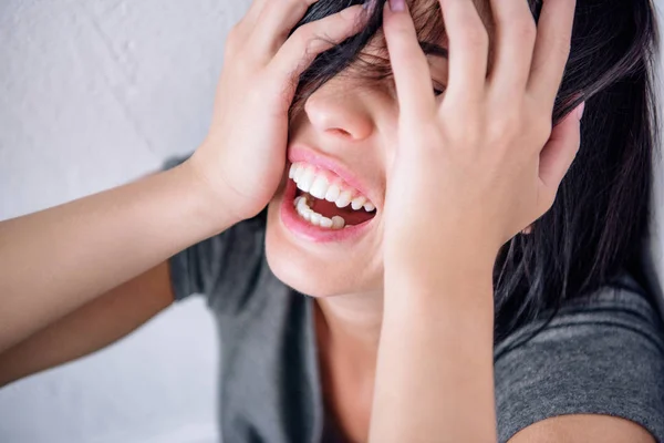 Chateado mulher morena solitária gritando e cobrindo rosto em casa — Fotografia de Stock