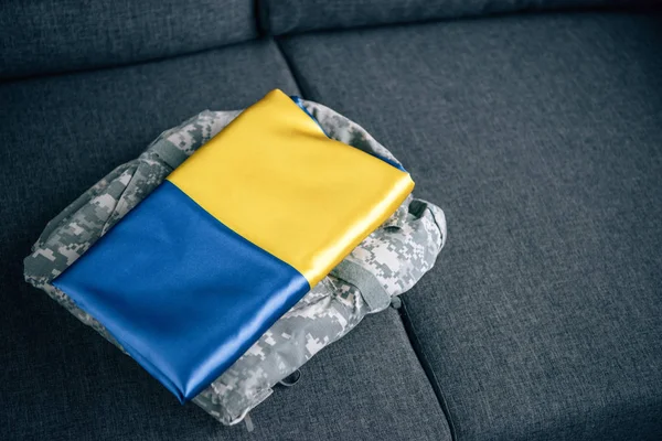 Ukrainian flag and military clothing on couch at home — Stock Photo