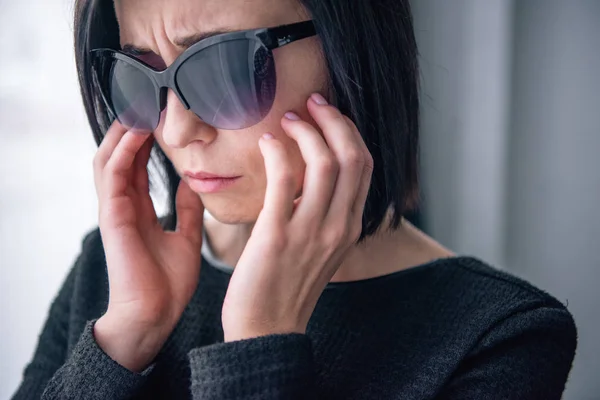 Femme solitaire déprimée dans les lunettes de soleil deuil à la maison — Photo de stock