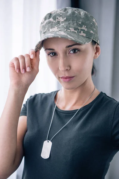 Beautiful woman in military uniform looking at camera at home — Stock Photo