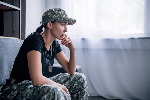 Depressive einsame Frau in Militäruniform zu Hause — Stockfoto