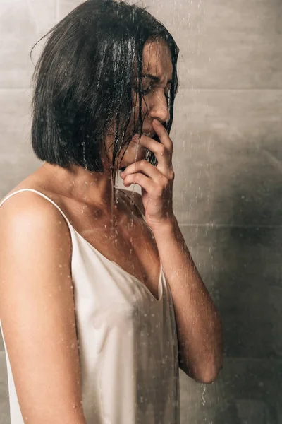 Одинокая депрессивная женщина, прикрывающая рот и плачущая дома в душе — стоковое фото