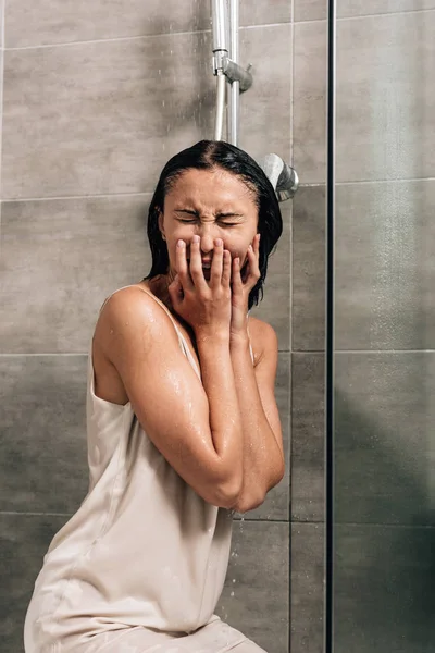 Mujer frustrada solitaria llorando en la ducha en casa - foto de stock