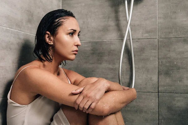 Mujer triste sola sentada en la ducha en casa - foto de stock