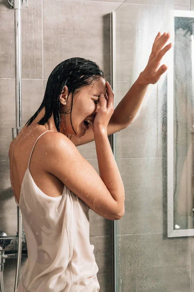 Femme frustrée solitaire couvrant le visage et pleurant dans la douche à la maison — Photo de stock