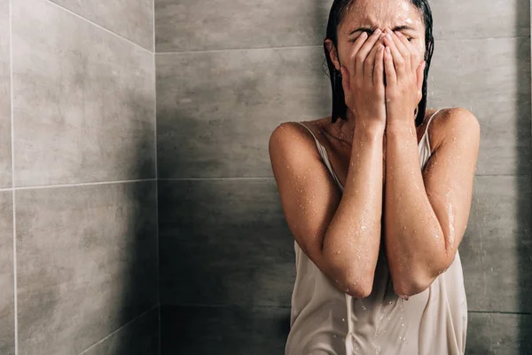 Mulher triste solitária cobrindo rosto e chorando no chuveiro em casa com espaço de cópia — Fotografia de Stock