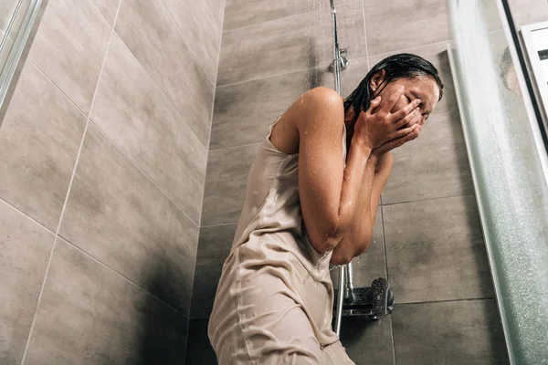 Депресивна жінка покриває обличчя руками, плачучи в душі вдома — стокове фото