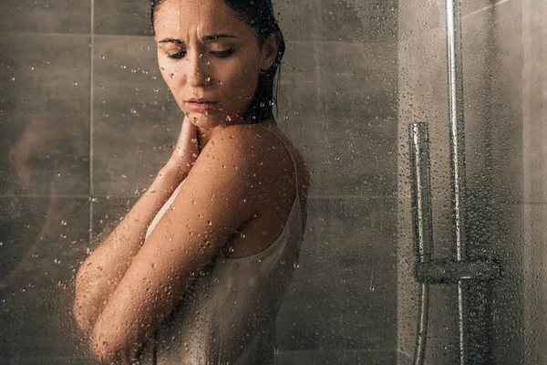 Bela mulher triste no chuveiro em casa através de vidro com gotas de água — Fotografia de Stock