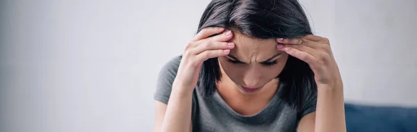 Panoramic shot of depressed brunette woman with hands on head at home — Stock Photo