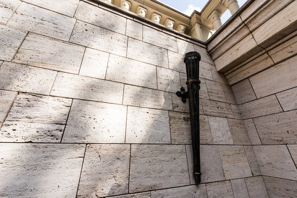 Ancienne torche de fer sur mur de béton blanc à l'extérieur — Photo de stock