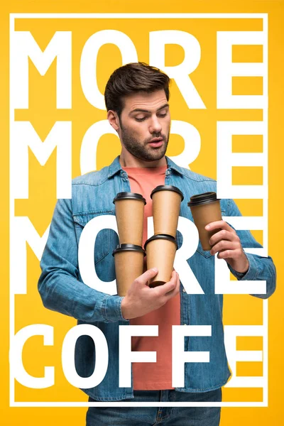 Homem bonito segurando copos de papel com café para ir isolado em amarelo com mais ilustração de café — Fotografia de Stock