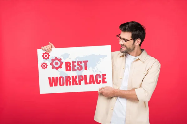 Hombre guapo sosteniendo pancarta blanca con la mejor ilustración del lugar de trabajo aislado en rojo - foto de stock