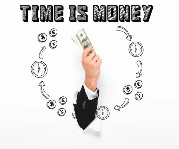 Cropped view of man holding money through hole in white paper wall on white with time is money illustration — Stock Photo