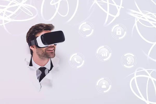 Homme souriant dans le casque de réalité virtuelle dans le trou dans le mur avec illustration de cyberespace lumineux — Photo de stock