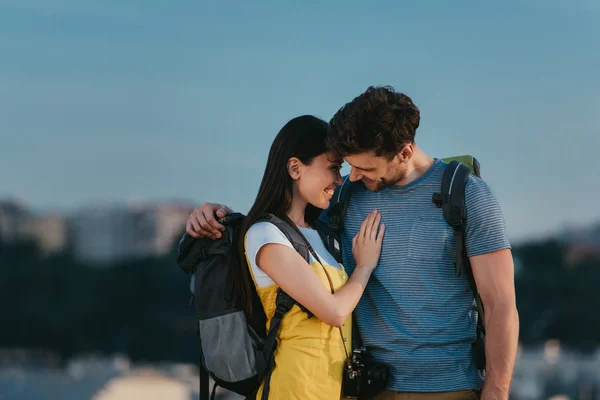 Bel homme et asiatique femme souriant et étreignant à l'extérieur — Photo de stock